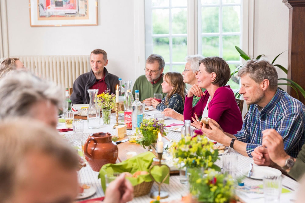 Eine Gruppe Menschen sitzt zusammen an einem großen Tisch