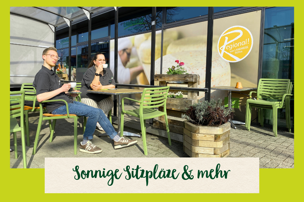 Zwei Mitarbeiter sitzen auf den neuen Sitzplätzen vor dem Bio-Markt am Kamp in der Sonne
